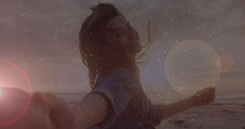 Woman Joyfully Spinning on Beach with Vintage Flare