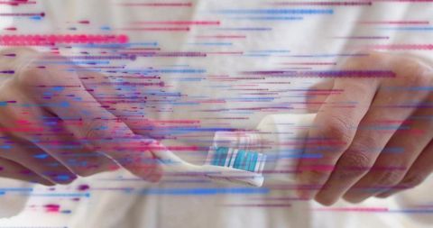 Male hands squeezing toothpaste onto blue toothbrush with colorful digital glitch
