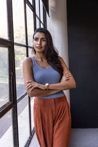 Confident woman in studio setting with industrial windows