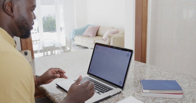 African American man using laptop on kitchen counter - Download Free Stock Images Pikwizard.com