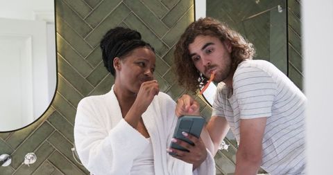 Playful Couple Brushing Teeth Together in Modern Bathroom