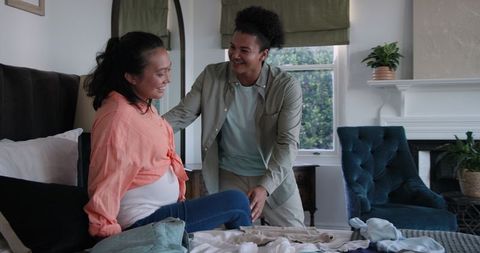 Expecting couple sharing joyful moment discussing baby clothes