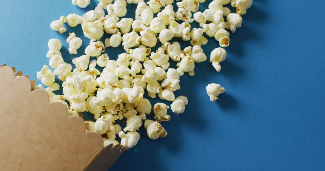 Spilled Box of Popcorn on Blue Background, Party Snack - Download Free Stock Images Pikwizard.com