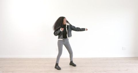 Energetic Young Woman Dancing in Trendy Apparel