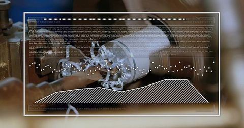 Spinning wooden blank on lathe producing curly shavings with hud overlay for precision