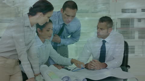 Business Team Discussing Network Data Over Blueprints