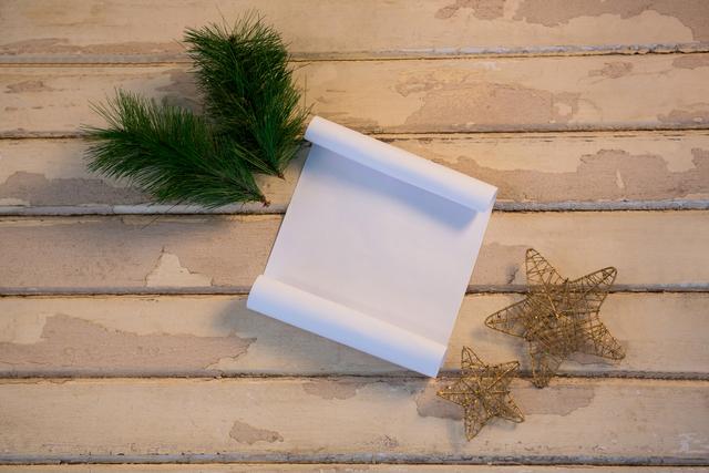 Christmas fir, star and paper on wooden plank during christmas time