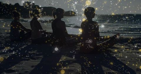 Four women meditating on sunset beach with golden bokeh overlay and ocean silhouettes