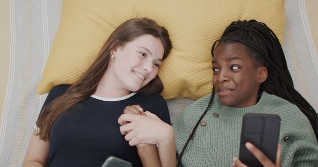 Smiling Teenage Friends Lying on Bed with Smartphones - Download Free Stock Images Pikwizard.com