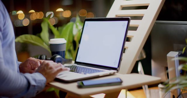 Person Working on Laptop at Ergonomic Desk with Warm Lighting - Download Free Stock Images Pikwizard.com