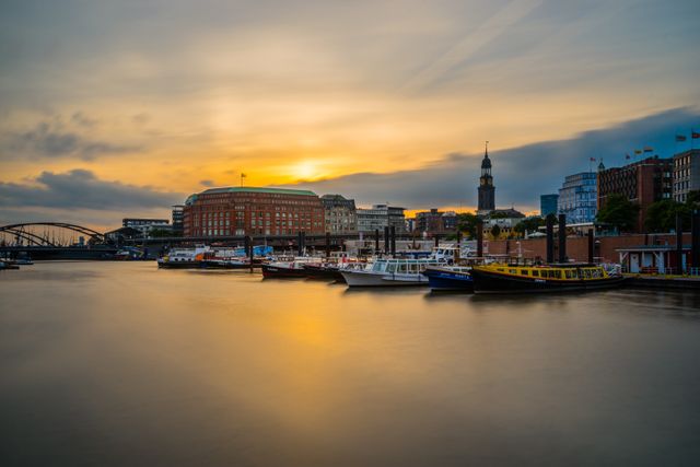 Ideal for travel blogs, tourism websites, and modern cityscape projects, this image beautifully captures sunset light reflecting on a tranquil harbor with boats and urban skyline in the background, evoking calm and peaceful vibes.
