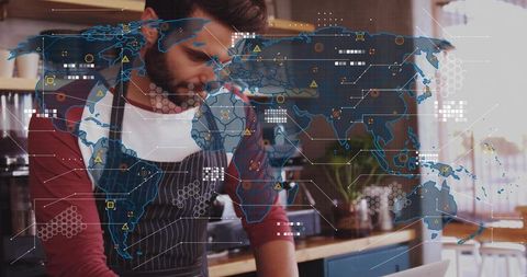 Bearded barista checking laptop with global network overlay, cafe analytics concept