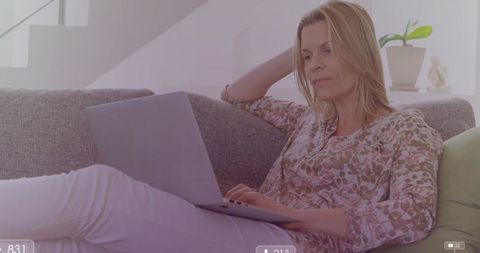 Woman using laptop in cozy living room