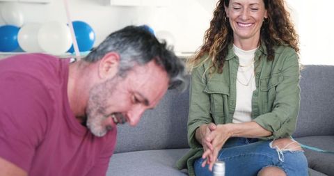 Smiling couple celebrating birthday at home with cupcakes