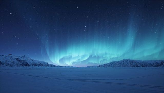 Aurora borealis illuminating arctic night sky over frozen tundra and snowy mountain horizon