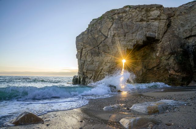 Sunlight Breaking Through Rocky Arch at Picturesque Ocean Shore - Download Free Stock Photos Pikwizard.com