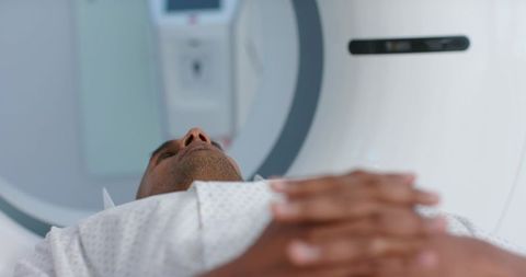 African american man lying in ct scanner undergoing diagnostic radiology scan in hospital