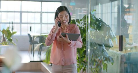 Asian Businesswoman Communicating via Smartphone and Tablet in Modern Office - Download Free Stock Images Pikwizard.com