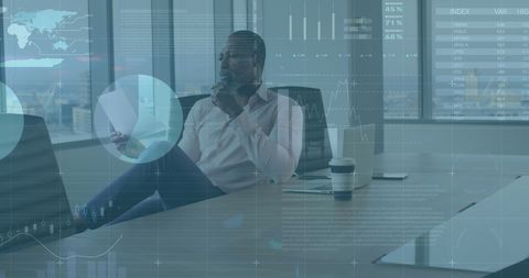 Businessman analyzing reports with virtual infographics overlay