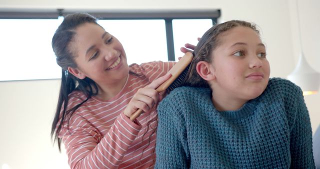 Mother Brushing Daughter's Hair in Cozy Home Setting - Download Free Stock Images Pikwizard.com