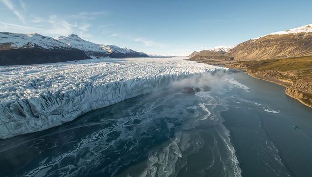 Majestic glacier ice wall meeting serene deep blue lake