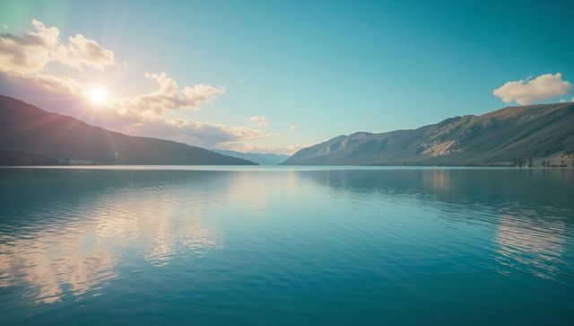 Tranquil alpine lake reflecting sunlit skies