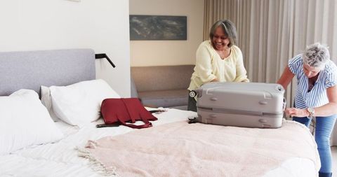 Senior Lesbian Couple Packing for a Trip in Bedroom
