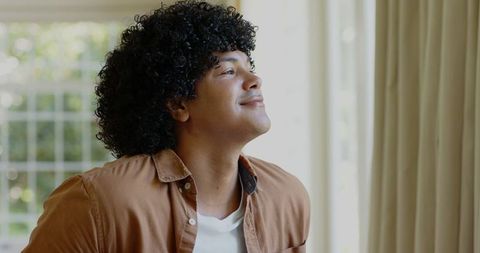 Thoughtful Man Relaxing Indoors with Natural Light