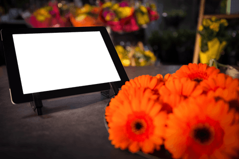 transparent tablet display amid vibrant orange flowers in shop - Download Free Stock Videos Pikwizard.com