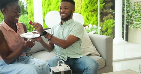 Couple Sharing Fruit and Gifts in Relaxing Outdoor Setting