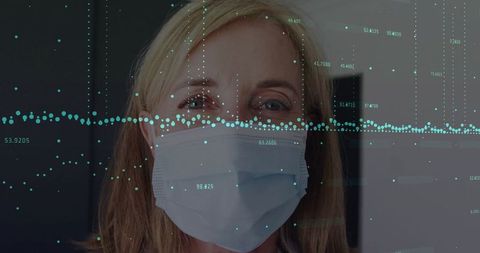 Woman in Mask Monitored by Digital Interface in Medical Setting