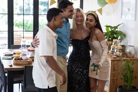 Friends Celebrating Birthday in Cozy Home Dining Room with Gifts