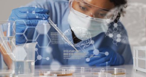 Female scientist in protective gear conducting laboratory experiment