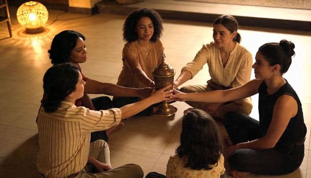 Women gathering in circle holding ornate urn during intimate remembrance ritual
