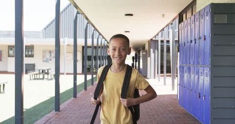 Smiling Schoolboy with Backpack in Corridor