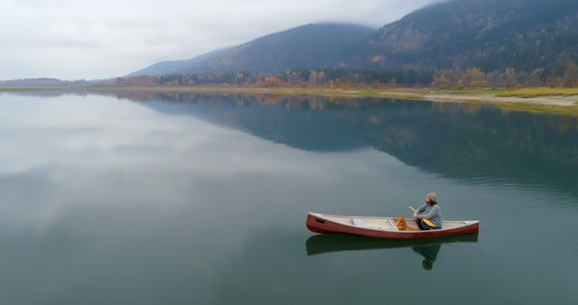 Man Canoeing in Serene Mountain Lake - Download Free Stock Images Pikwizard.com
