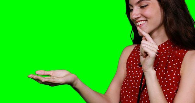 Smiling Woman Pointing at Open Hand, Isolated on Green Background - Download Free Stock Images Pikwizard.com