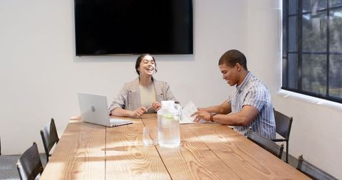 Happy Business Colleagues Discussing in Modern Office Meeting Room