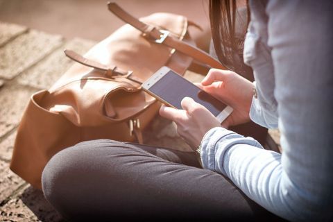 Young Woman Texting on Smartphone Outdoors