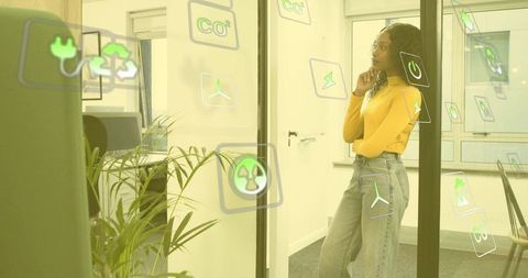 Woman Examining Sustainability Icons in Modern Office Environment