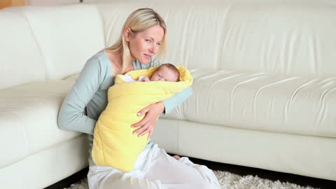 Mother Bonding with Newborn Wrapped in Yellow Blanket Indoors