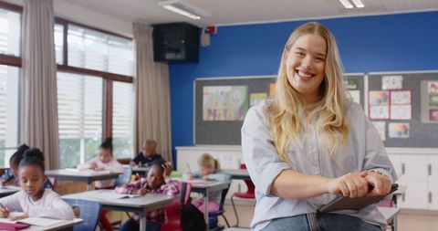 Confident teacher guiding young students in vibrant classroom