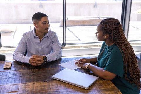 Diverse coworkers collaborating at office table for business discussion