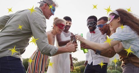 Diverse Friends at Masked Party Celebrating Outdoors with Drink Toast