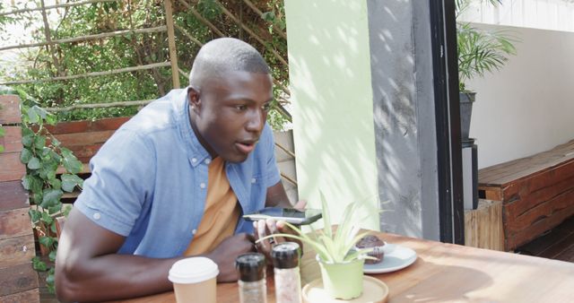 Young Man Using Smartphone in Outdoor Café - Download Free Stock Images Pikwizard.com