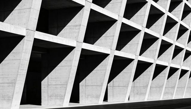 Diagonal Concrete Facade Featuring Repeating Triangular Recesses and Dramatic Shadows