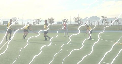 Field hockey team training on turf with coach passing dribbling cones wavy light streaks