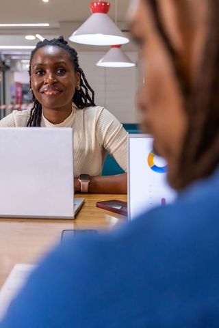Smiling African American Woman Working with Laptop in Modern Coworking Space