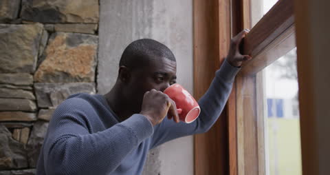 Man Relaxing by Window with Morning Coffee
