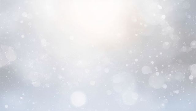 Soft gray-blue winter bokeh evoking falling snow, frosty sparkle and gentle glow